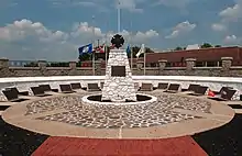 Circular plaza with sculpture of a cross in the center and plaques on the outside