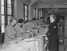 Ladies in a warehouse assembling care packages for soldiers during World War II