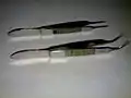 Upper one: Suture tying forceps; Lower one: Iris forceps; For comparison